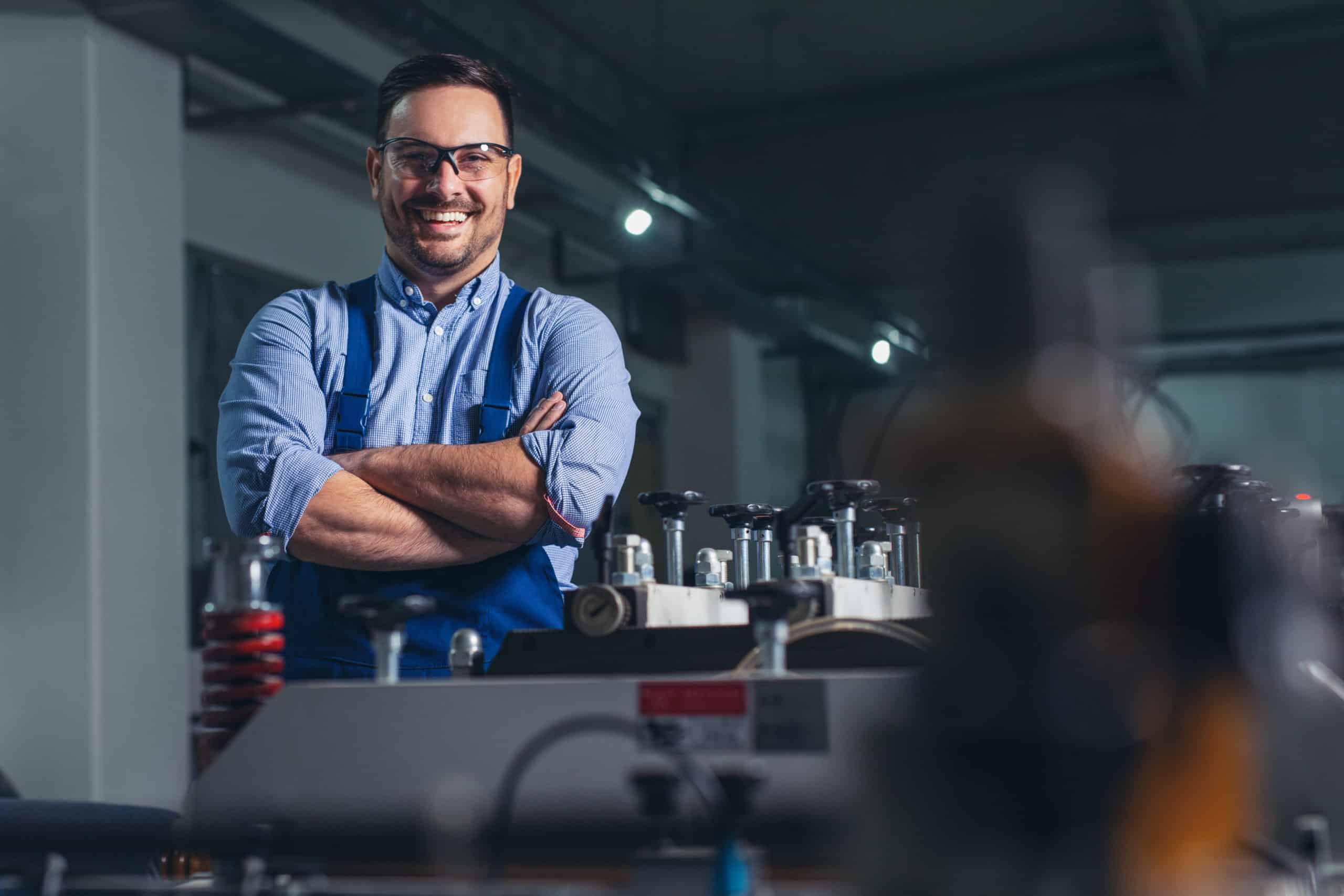 Cheerful factory worker with arms crossed.