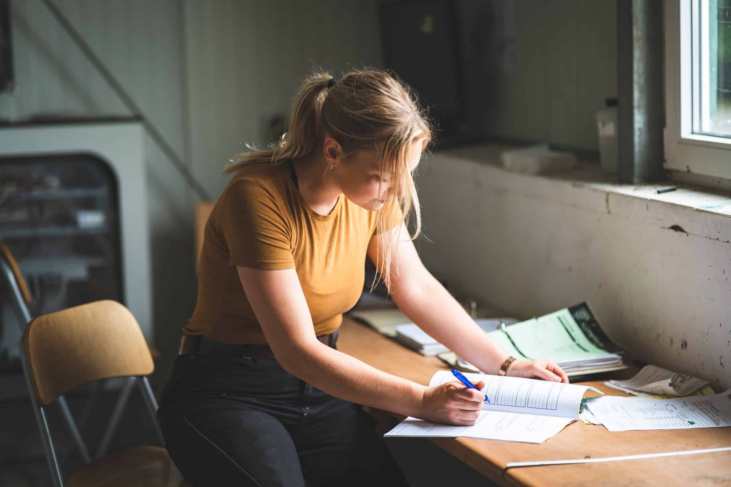 eine junge Frau studiert am Tisch