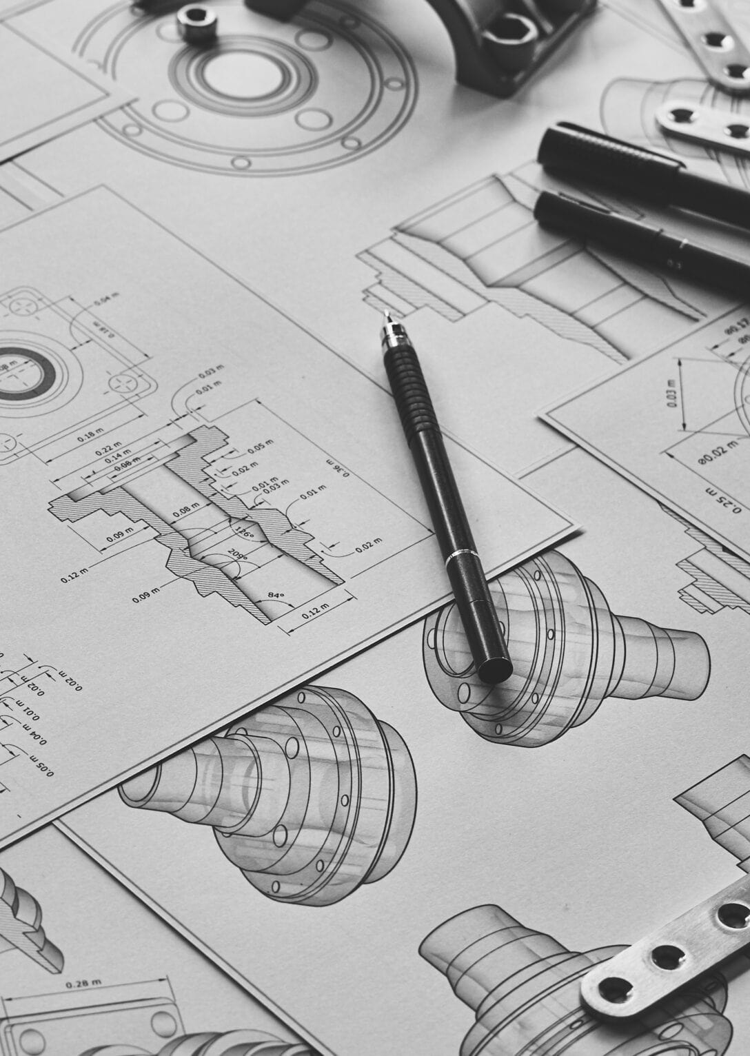 Technische Zeichnung mit Ausschnitt eines Werkstücks Eine großflächige Technische Zeichnung ist ausgebreitet. Im Fokus ist ein Ausschnitt eines Werkstücks, welches ebenfalls mit auf der Zeichnung liegt. Daneben ein Messschieber und ein Stift.